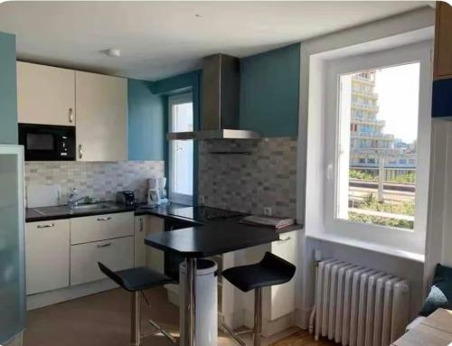 une cuisine avec une table et des chaises et une fenêtre dans l'établissement Maison hyper centre 2 pas de la plage, à Dinard