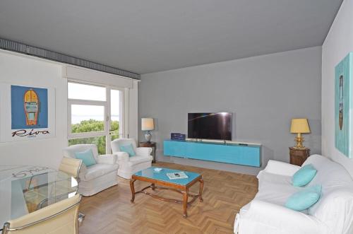 a living room with two white couches and a tv at Hotel Spiaggia d'Oro - Charme & Boutique - Garda Lake Collection in Salò