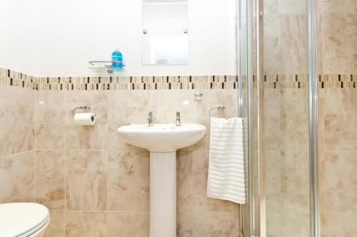 a bathroom with a sink and a shower at Avon Beach Bed & Breakfast in Christchurch