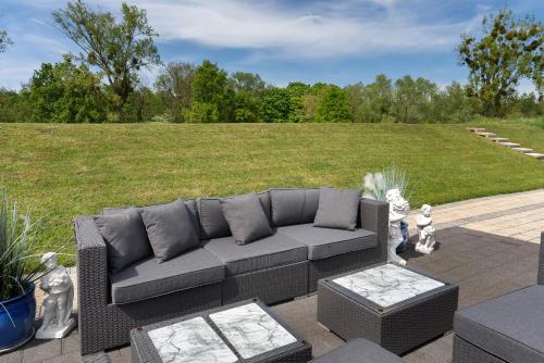 a couch sitting on a patio with a grass field at Gästesuite in Kehl am Rhein
