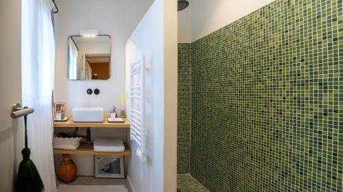 a bathroom with a green tiled shower with a mirror at Villa d'Artiste en pleine pinède à 10 min d'Aix in Meyreuil