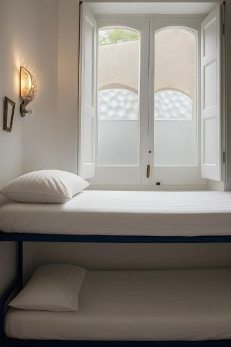 a window in a room with a mattress and a window sill at Hostel Brikette in Positano
