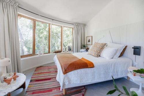 a bedroom with a bed and a large window at Villa d'Artiste en pleine pinède à 10 min d'Aix in Meyreuil