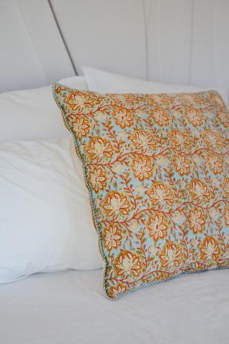 a pillow sitting on top of a bed at Villa d'Artiste en pleine pinède à 10 min d'Aix in Meyreuil