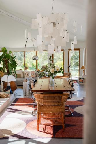 a living room with a table and a chandelier at Villa d'Artiste en pleine pinède à 10 min d'Aix in Meyreuil