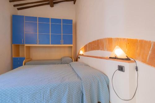 a bedroom with two beds and blue cabinets at Casa Di Dea in Porto Azzurro