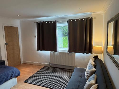 a living room with a couch and a window at Apartment close to London Stansted airport in Great Parndon