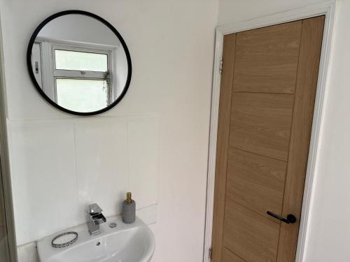 a bathroom with a sink and a mirror on the wall at Apartment close to London Stansted airport in Great Parndon