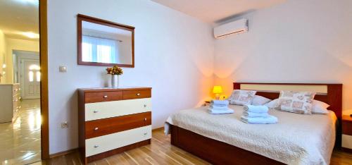 a bedroom with a bed with a dresser and a mirror at Villa Ana with a private pool on a 3000m2 property in Čvrljevo