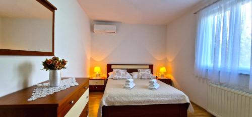 a bedroom with a bed and a vase of flowers at Villa Ana with a private pool on a 3000m2 property in Čvrljevo