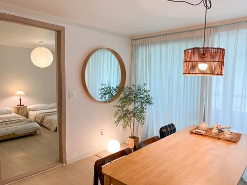 a room with a dining table and a bedroom at JAJA Haenggung, SuwonㅣNext to Hwaseong FortressㅣCozy Korean VibeㅣComfortable & Well-keptㅣUp to 8 guestsㅣFree Parkingㅣ2-night minimumㅣLoved by many guests in Suwon