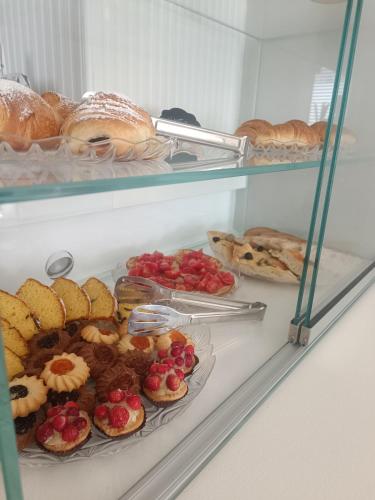 a refrigerator filled with different types of pastries and bread at Relais Tiaré Bed and Breakfast in Bacoli