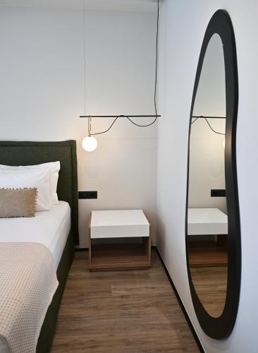 a bedroom with a bed with a mirror and a table at Asters Hotel in Ksamil