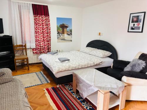 una sala de estar con dos camas y un sofá en Apartments Kira, en Sarajevo