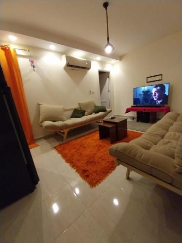 a living room with two couches and a flat screen tv at بورتو السخنه هيفين هيلز شاليه عائلات Heaven Hills Porto El sokhna in Ain Sokhna