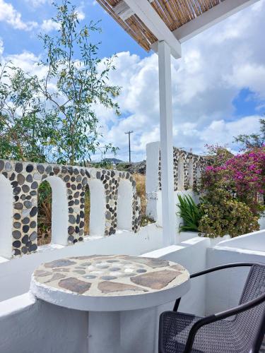 a patio with a table and chairs on a porch at Calypso Heaven in Santorini