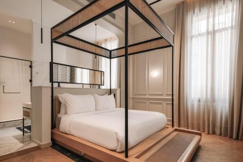 a bedroom with a canopy bed with white pillows at Mazeej Balad - Boutique Hotel - Adult Only in Cairo