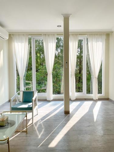 a living room with large windows and a couch at De Lavender Villa 2 in Citaringgul 1
