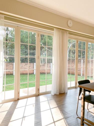 a living room with large windows and a table at De Lavender Villa 2 in Citaringgul 1