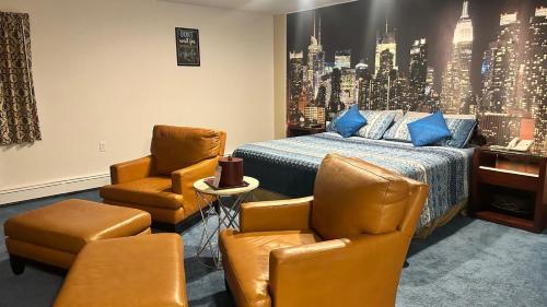 a bedroom with a bed and two chairs and a table at Chesaning INN & Suites in Chesaning