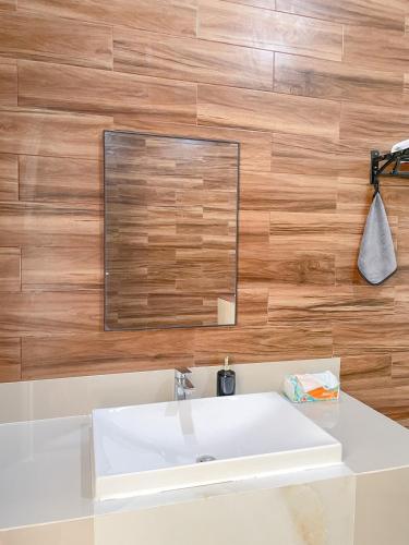 a bathroom with a white sink and a mirror at De Lavender Villa 2 in Citaringgul 1