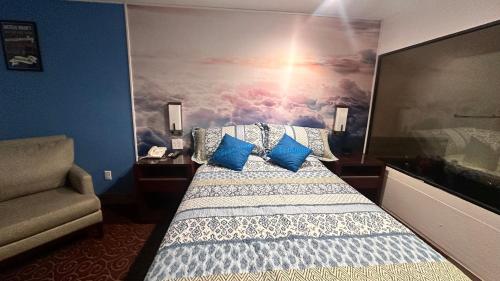 a bedroom with a bed with a painting on the wall at Chesaning INN & Suites in Chesaning