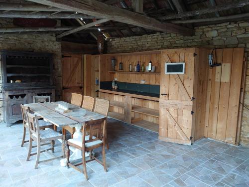 a kitchen with a wooden table and chairs at Chambre d'hôtes Juste-Confortable in Fleurey-lès-Lavoncourt
