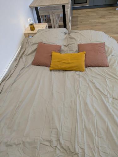 un grand lit blanc avec deux oreillers dessus dans l'établissement Agréable dépendance !, à Le Bignon