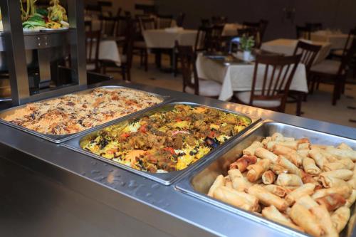 two trays of food on a buffet table in a restaurant at Abraj Al Tayseer Tuwa Hotel in Makkah