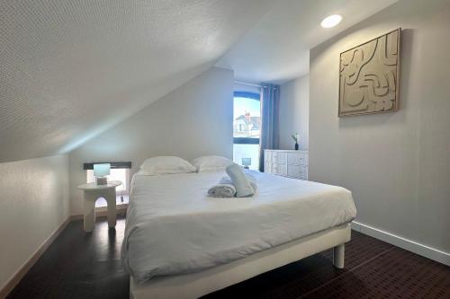 une chambre avec un lit blanc avec une fenêtre dans l'établissement Casa Foch - T3 pour 3 personnes - Parking - Proche Hyper Centre, à Brive-la-Gaillarde