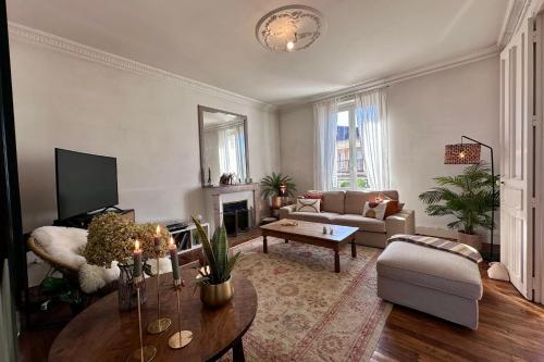 un salon avec un canapé et une table dans l'établissement Casa Jaurès - T4 style haussmannien - Proche gare - Place de parking, à Brive-la-Gaillarde