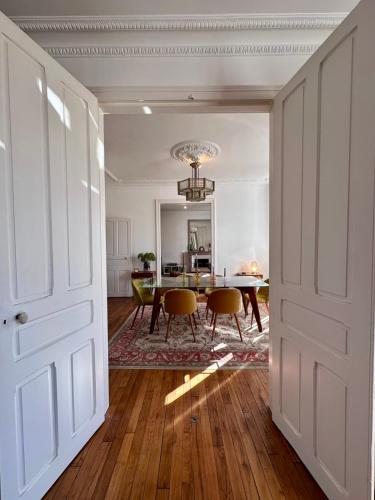 une pièce avec une table et des chaises et une salle à manger dans l'établissement Casa Jaurès - T4 style haussmannien - Proche gare - Place de parking, à Brive-la-Gaillarde