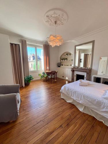 une chambre avec un lit et une table dedans dans l'établissement Casa Jaurès - T4 style haussmannien - Proche gare - Place de parking, à Brive-la-Gaillarde
