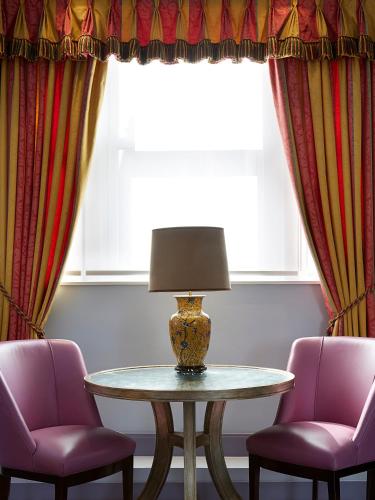 a table with two chairs and a lamp in a room at The Mandeville Hotel in London