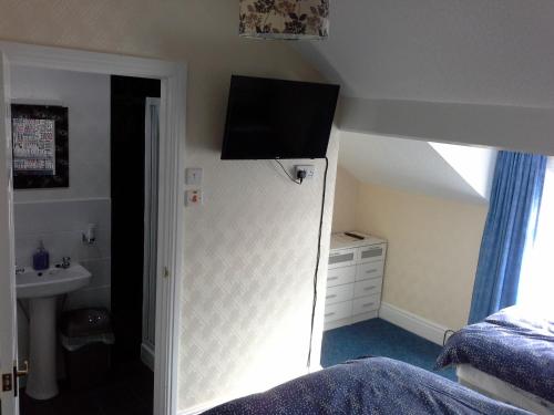 a bedroom with a bed and a television on the wall at The Trentham Hotel in Blackpool
