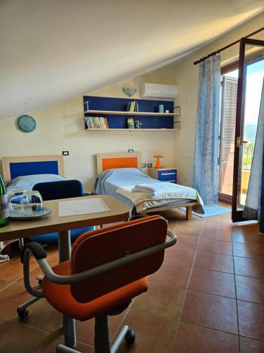 a bedroom with a bed and a desk with a chair at Villa Fiori e Sapori in Messina