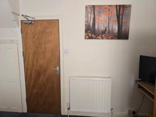 a door in a room with a picture on the wall at Realwood Homes- Birrell Road in Nottingham