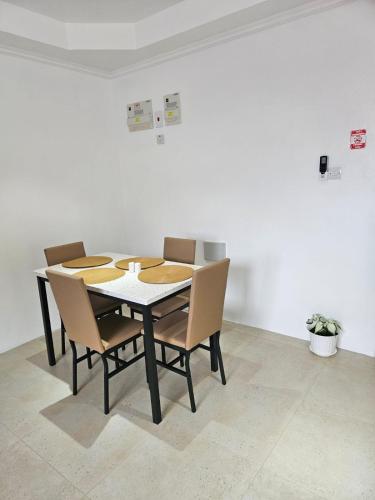 a dining room table with chairs and a white wall at Agape Suites-Room 4- 1st Floor in Soufrière