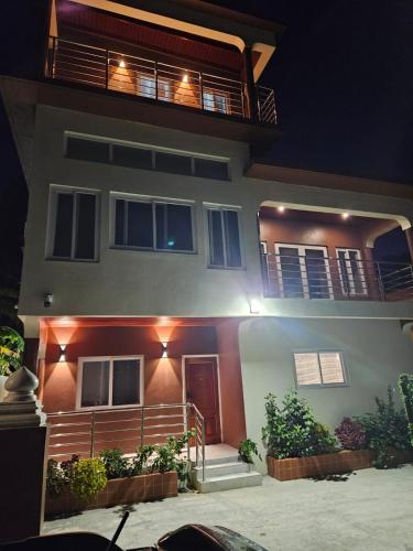 a house with a porch and a balcony at night at Agape Suites-Room 4- 1st Floor in Soufrière