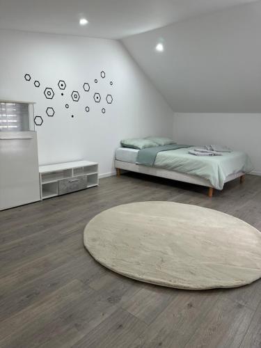 a bedroom with a bed and a large rug at Le nid du 4 in Épernay