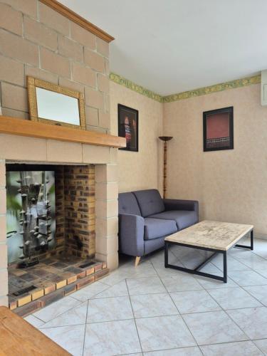 un salon avec un canapé et une cheminée dans l'établissement Pôle Européen du Cheval - Gîte de la Fromenterie, à Yvré-lʼÉvêque