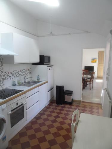 una cucina con mobili bianchi, un lavandino e un tavolo di Arcachonaise à 50 m de la plage, Arcachon Centre ad Arcachon