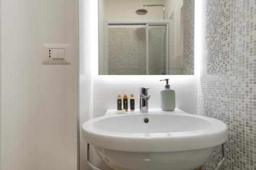 a bathroom with a white sink and a mirror at Elegantis Trastevere Modern Apartment - Comfort in Rome Most Charming District in Rome