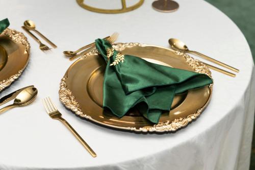 a gold plate with a green napkin on a table at Holiday Inn Abu Dhabi by IHG in Abu Dhabi