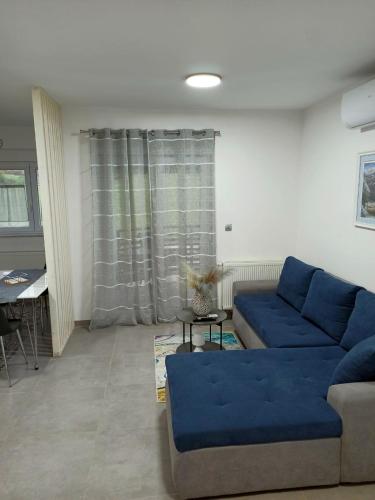 a living room with a blue couch and a table at Apartmani Leptir in Rakovica