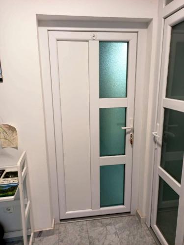 a bathroom with a door in a room at Apartmani Leptir in Rakovica