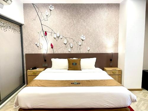 a bedroom with a bed and a wall with flowers at B.O.B Hotel in Cao Lãnh