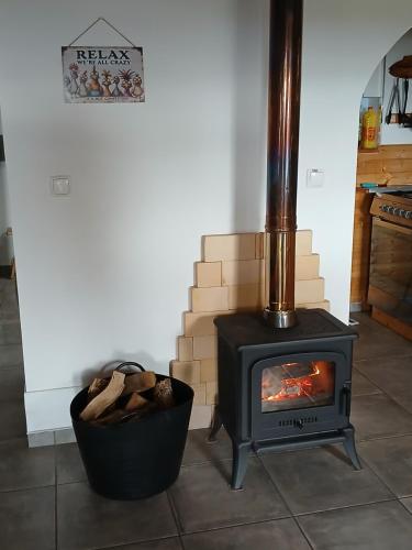 a stove in a room with a pot of logs at Casinha do Barreiro - Cosy Private Cottage in Vila do Porto