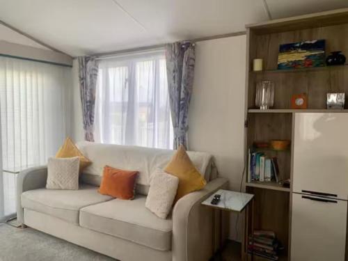 a living room with a white couch and a window at Findhorn Lodge - Peaceful - Pets - Sleeps 4 in Forres