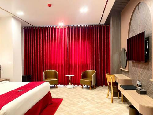a hotel room with a bed and a red curtain at B.O.B Hotel in Cao Lãnh